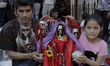 A father and daughter pose with a figure of Santa Muerte outside their church in Tepito, M...