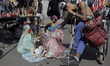 A young man in a wheelchair poses with a figure of Santa Muerte outside his church in Tepi...