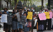 People hold banners and placards during a demonstration against the current economic crisi...