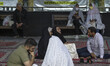 Iranian families sit in a holy shrine in northern Tehran on the first day of the holy mont...
