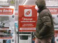 "please keept wearing face mask" sign is seen hanging in front of Media markt, the electronic restailer  in the city center of Cologne, Germ...