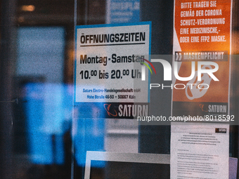 "please wear face mask in our store" sign is seen in front of Saturn, the electronic store in the city center of Cologne, Germany on April 4...
