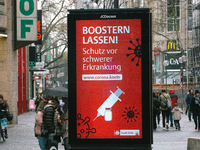 public information ad is seen to suggest people to " take a boost vaccine"  n the city center of Cologne, Germany on April 4, 2022 after Ger...