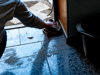 BUCHA, UKRAINE - APRIL 7, 2022 - A woman wipes the floor inside an apartment after the liberation of the city from Russian invaders, Bucha,...