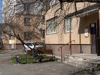 BUCHA, UKRAINE - APRIL 7, 2022 - An elderly woman soaks in the sun on a bench outside a residential building after the liberation of the cit...