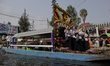 Representatives of La Flor Más Del Ejido in Xochimilco, Mexico City, aboard a canoe decora...