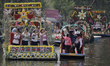 Representatives of La Flor Más Del Ejido in Xochimilco, Mexico City, aboard a canoe decora...