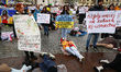 Ukrainian citizens and supporters lay on the ground playing dead while attending a silent...