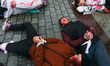 Ukrainian citizens and supporters lay on the ground playing dead while attending a silent...