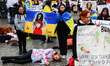 Ukrainian citizens and supporters lay on the ground playing dead while attending a silent...