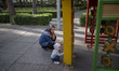 An Iranian woman takes care of her kid playing at a playground in an urban park in downtow...