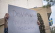 An Iranian man holds-up a placard during a protest gathering in front of the Sweden Embass...