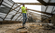 ZAPORIZHZHIA, UKRAINE - APRIL 16, 2022 - A labourer removes debris from the roof of a 70-y...