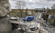 Local residents looks at bridge, destroyed in the Kukhari village during russian military...