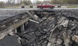 A view of a shell crater on a damaged bridge, destroyed during russian military invasion t...