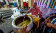 An elderly man is seen filling a can with Haleem , a traditional Mughlai soup , ahead of I...