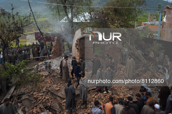 People assess the damaged residential house after an encounter between Indian forces and Militants came to end in Baramullah district of Ind...