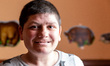 A young Ukrainian woman with learning disabilities smiles as she rests in a common room in...