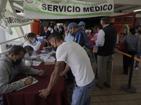 Medical personnel offer reports to people in a vaccination unit at the Constitución de 1917 metro station in Mexico City, where the AstraZen...