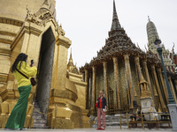 A foreign tourist poses for a photo during a visit at the Temple of the Emerald Buddha in Bangkok, Thailand, 01 May 2022. Thailand allowing...