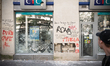The windows of many businesses of banks, insurance companies and real estate agencies were...