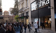 People are passing in front of a Bershka store at Ermou street in the center of Athens, Gr...