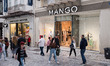 People are passing in front of a Mango store at Ermou street in the center of Athens, Gree...