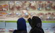 An Iranian woman picks-up a packed meat while shopping in Tehran's Megamall on September 3...