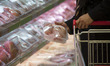 An Iranian woman holds a packed meat while shopping in Tehran's Megamall on September 30,...