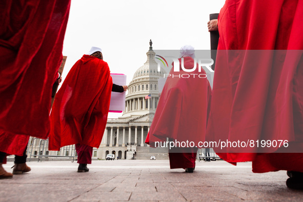 Members of Handmaids Army DC walk silently from theSupreme Court to the Capitol during a protest against the Court’s leaked preliminary deci...