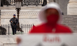 A Capitol Police officer armed with an assault rifle watches a protest by the Handmaids Ar...