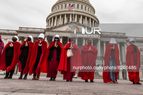 Demonstrators dressed as handmaids from The Handmaid's Tale, walk to the Capitol during a protest by the Handmaids Army DC of the  Supreme C...