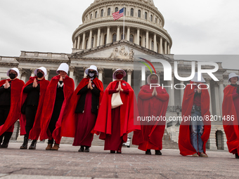 Demonstrators dressed as handmaids from The Handmaid's Tale, walk to the Capitol during a protest by the Handmaids Army DC of the  Supreme C...