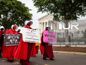Demonstrators dressed as handmaids from The Handmaid's Tale, walk in front of the Supreme Court.  The Handmaids Army DC protested the Suprem...