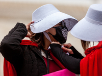A demonstrator dressed as a handmaid from The Handmaid's Tale helps another tie her bonnet at a protest by the Handmaids Army DC of the  Sup...