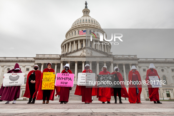 Demonstrators dressed as handmaids from The Handmaid's Tale, stand in front of the Capitol during a protest by the Handmaids Army DC of the...