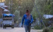 A man walks as breeze carries waves of fresh female Russian poplar pollen In Sopore, Distr...