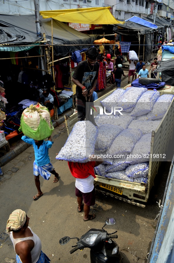 A day labour carry a sack of vegetables in a wholesale market in Kolkata, India, 13 May, 2022. Rising food and energy prices pushed India's...