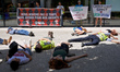 Die-in in front of the place where the summit takes place. The banner reads 'We don't have...