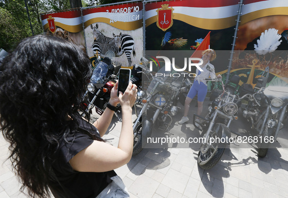 Ukrainians take a photo in front of motorbikes of bikers from 'One Spirit Brotherhood' motorcycle club during a Volunteer Day celebration in...