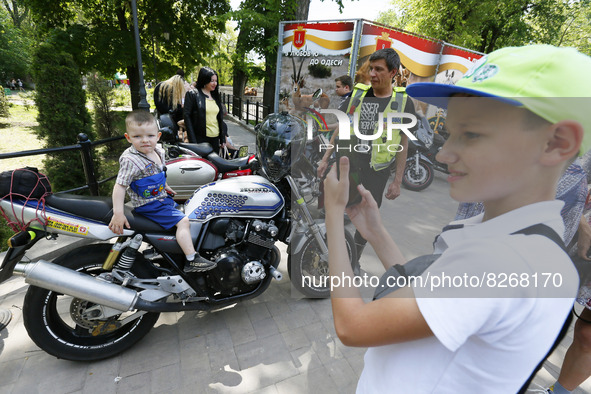 Ukrainians look on motorbikes of bikers from 'One Spirit Brotherhood' motorcycle club during a Volunteer Day celebration in Odesa, Ukraine o...