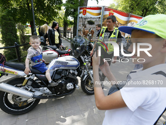 Ukrainians look on motorbikes of bikers from 'One Spirit Brotherhood' motorcycle club during a Volunteer Day celebration in Odesa, Ukraine o...