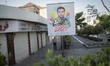 Two men under a billboard with a portrait of the Islamic Revolutionary Guard Corps' (IRGC)...