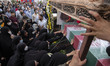 Iranian veiled women pray next to the coffin containing the body of the Islamic Revolution...