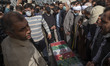 Iranian cleric, Ayatollah Kazem Seddighi (Center R), prays next to the coffin containing t...