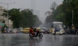 A bike rider crosses a road during heavy rainfall in Kolkata, India, 26 May, 2022.  