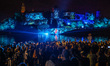 People watch mapping with music while being screened on the Wawel Castle to celebrate the...