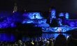 People watch mapping with music while being screened on the Wawel Castle to celebrate the...