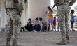 Migrants await porcessing by Border Patrol after just having corssed the Rio Grande on May...