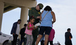 A little girl looks at her mothers identification tag  issued by Border Patrol after havin...